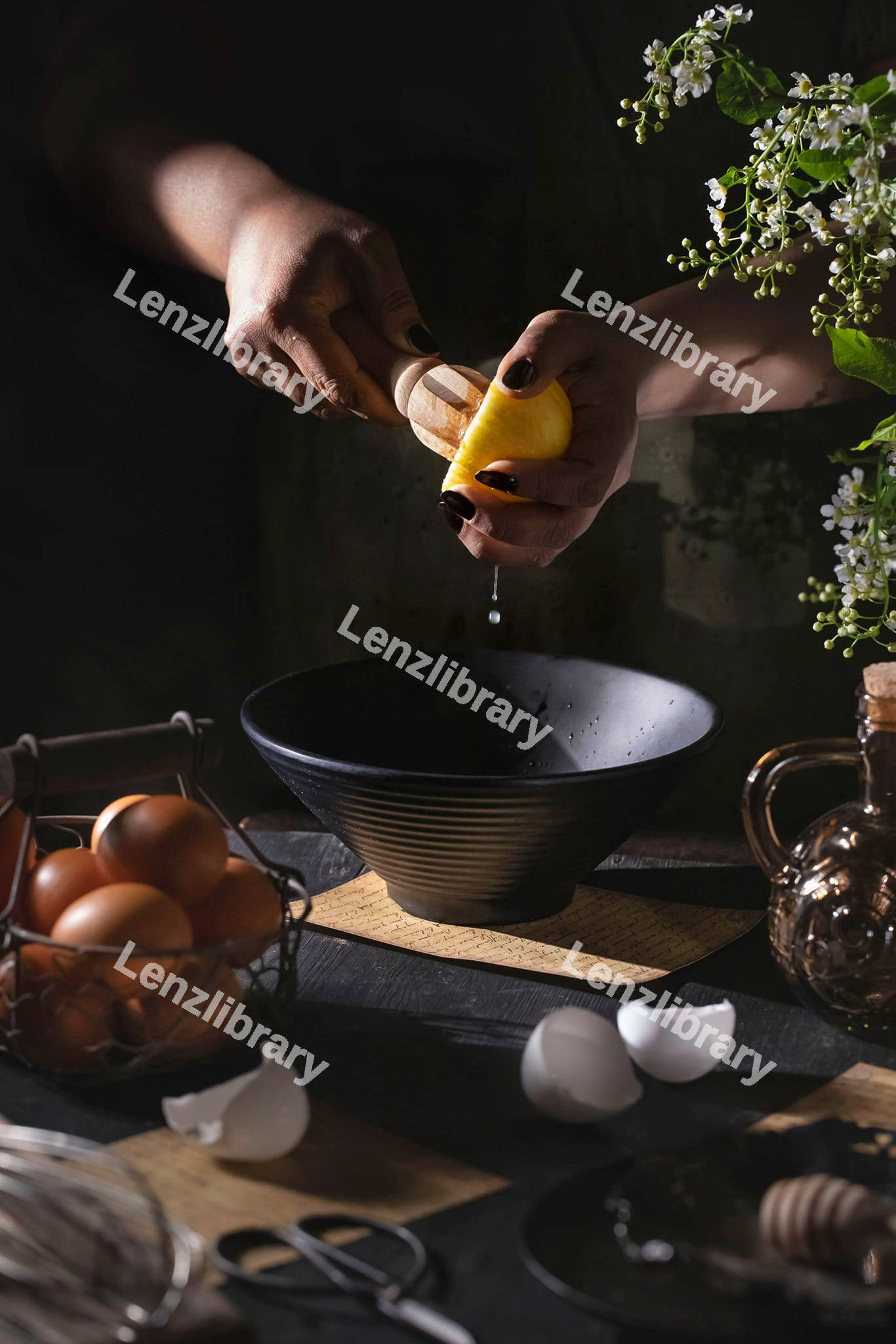 A woman squeezing lemon into a bowl